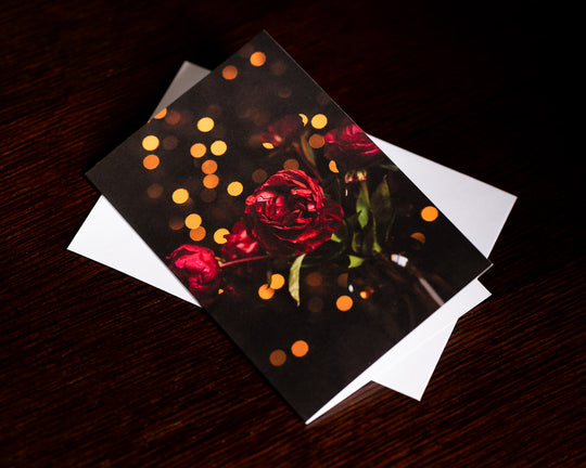 Blank Christmas card with red flowers and twinkly lights