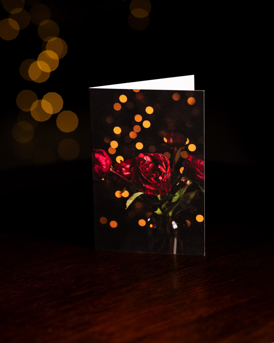 Red peonies in a vase with fairy lights card